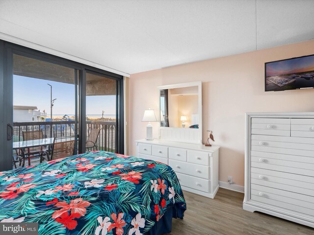 11500 Coastal Hwy Unit 103, Ocean City, MD 21842 - bedroom with access to outside, wood finished floors, and baseboards