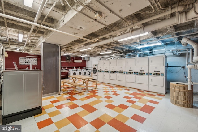 basement featuring stacked washer / drying machine and washer and clothes dryer