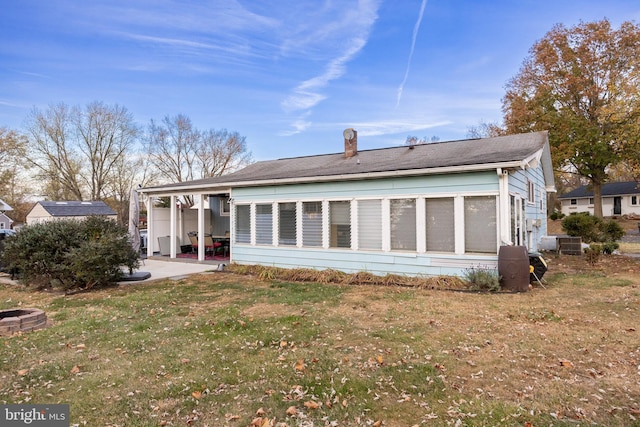 rear view of house featuring a lawn and a patio