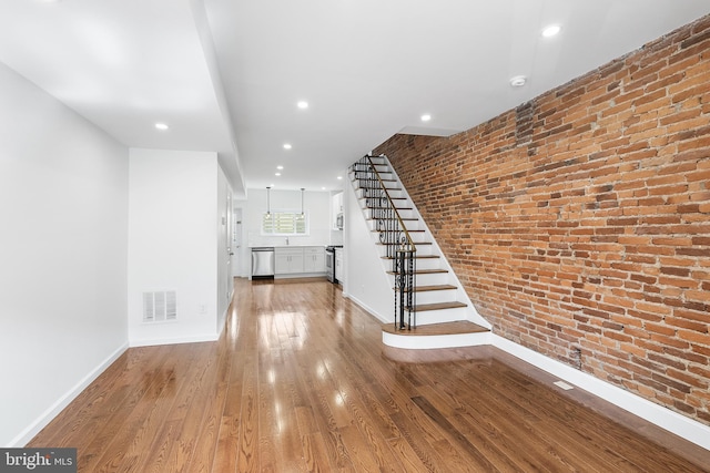 interior space featuring light hardwood / wood-style flooring and brick wall