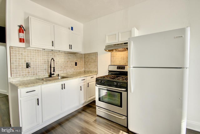 kitchen with decorative backsplash, sink, white cabinets, white fridge, and stainless steel range with gas cooktop