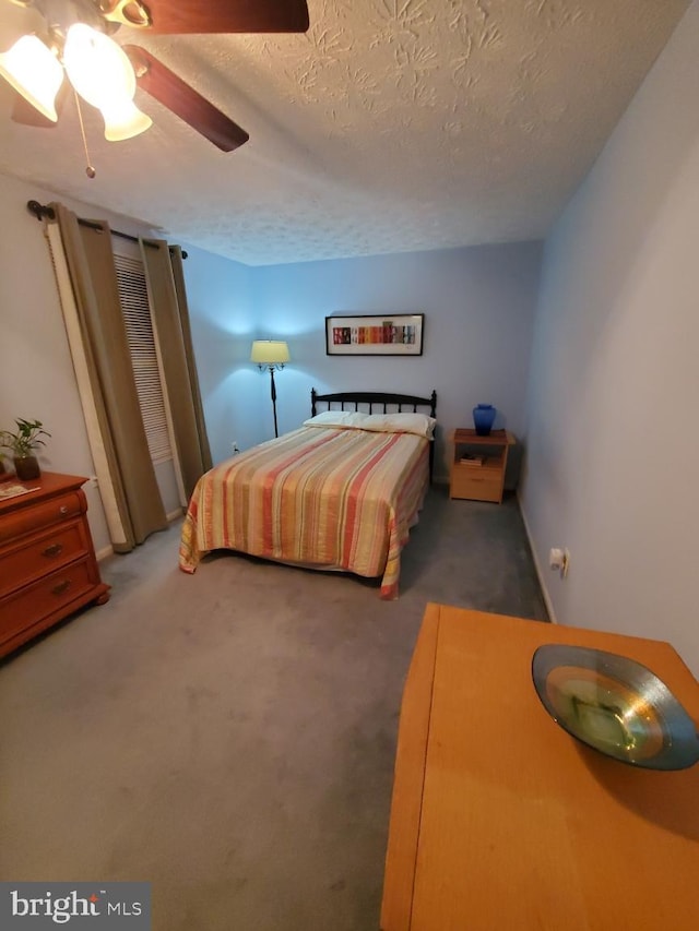 bedroom featuring a textured ceiling, ceiling fan, and carpet