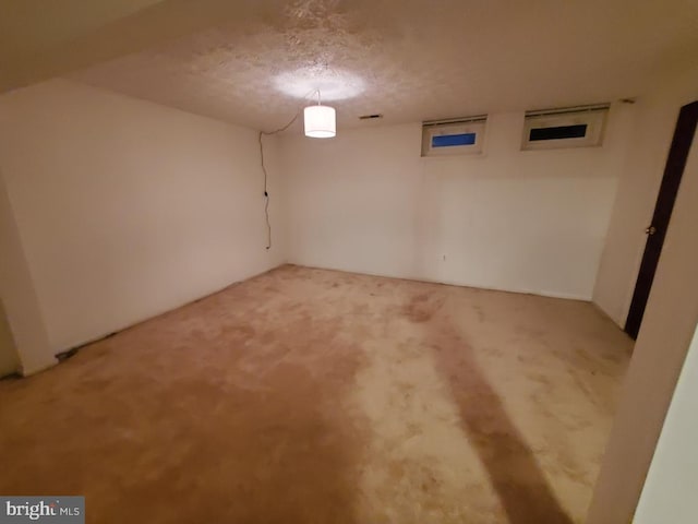 basement featuring carpet floors and a textured ceiling