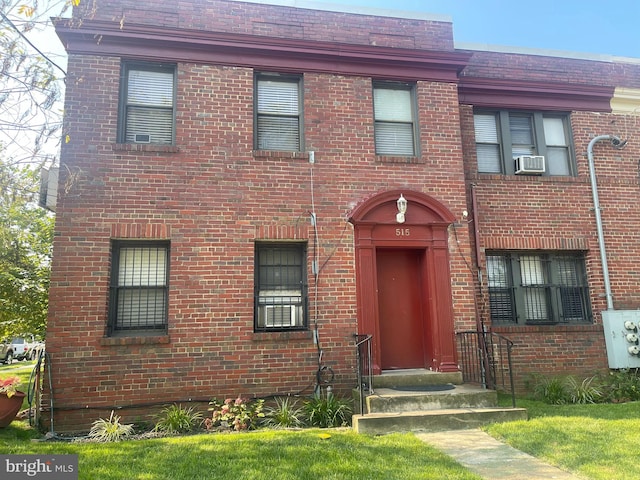 view of front facade with a front yard and cooling unit