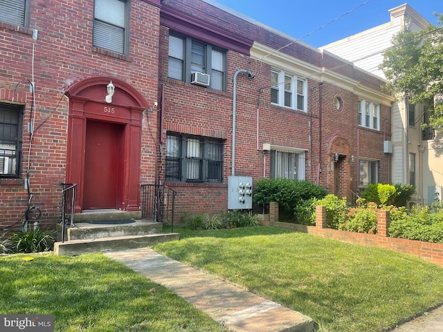 doorway to property with a lawn and cooling unit