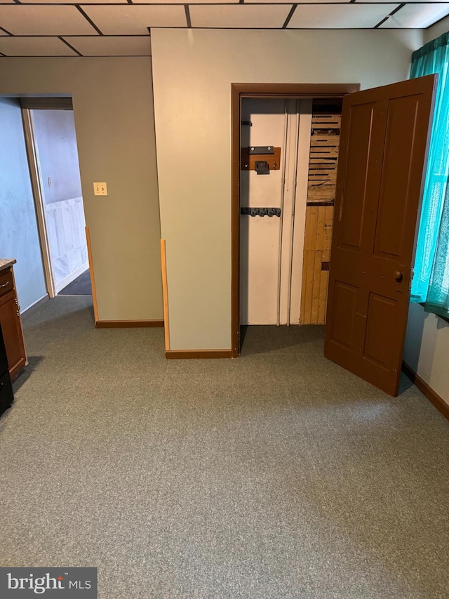 unfurnished room with a paneled ceiling and light colored carpet