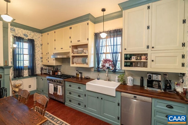 kitchen with pendant lighting, sink, butcher block counters, and stainless steel appliances