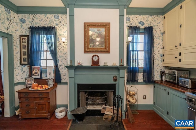 sitting room with plenty of natural light, dark hardwood / wood-style floors, and ornamental molding