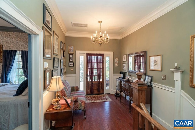 entrance foyer featuring a wealth of natural light, dark wood-type flooring, a notable chandelier, and ornamental molding