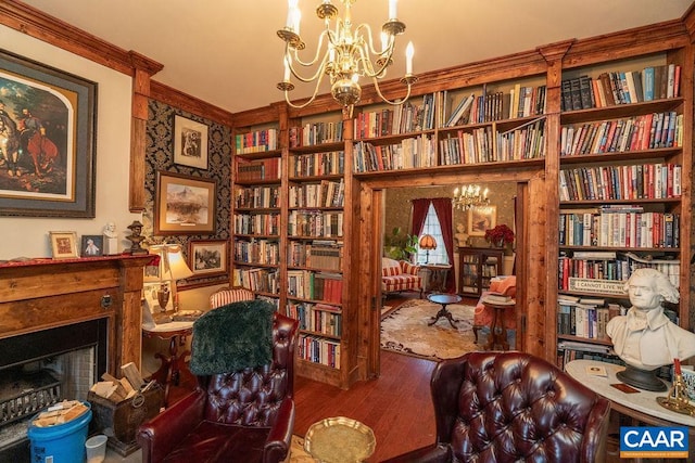 living area with hardwood / wood-style floors, ornamental molding, and an inviting chandelier