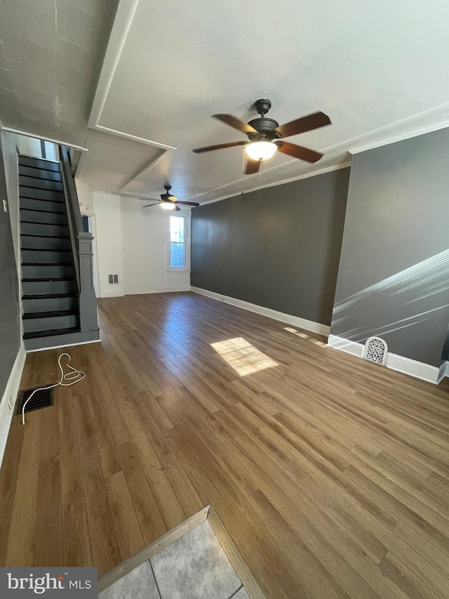 unfurnished living room with ceiling fan, hardwood / wood-style flooring, and crown molding