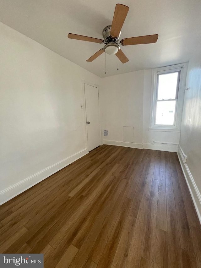 empty room featuring dark wood-type flooring and ceiling fan