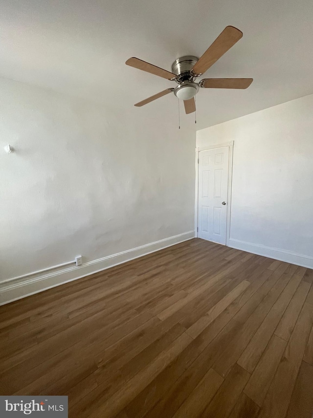 empty room with ceiling fan and dark hardwood / wood-style flooring