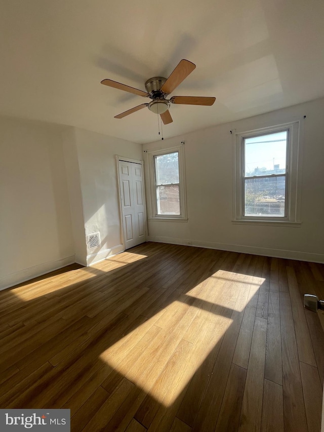 spare room with ceiling fan, wood-type flooring, and plenty of natural light