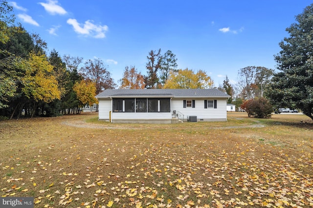 rear view of house with central air condition unit and a sunroom