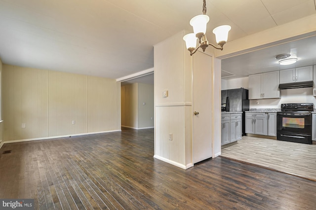 kitchen featuring pendant lighting, gray cabinetry, black appliances, and dark hardwood / wood-style flooring