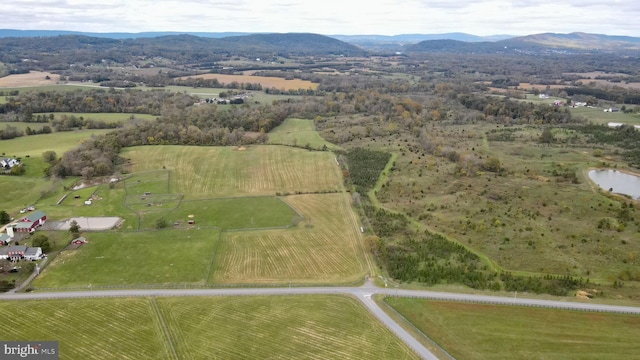 drone / aerial view with a water and mountain view and a rural view