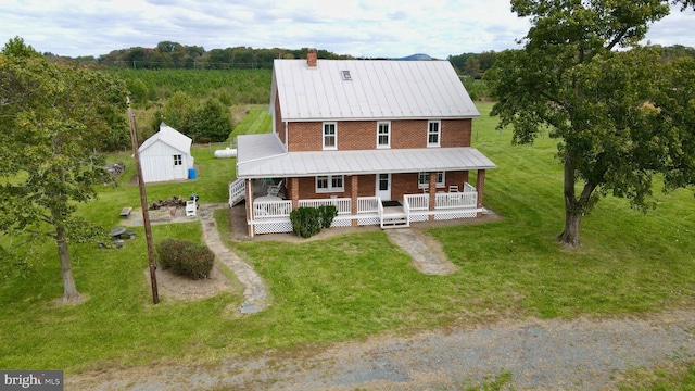 43086 Lucketts Rd, Leesburg, VA 20176 - view of front of home featuring covered porch, an outdoor structure, brick siding, a front lawn, and a chimney