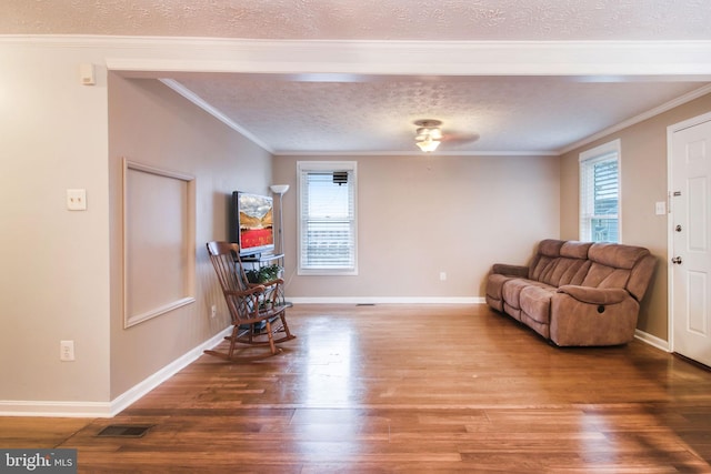 sitting room featuring hardwood / wood-style floors, a textured ceiling, and crown molding