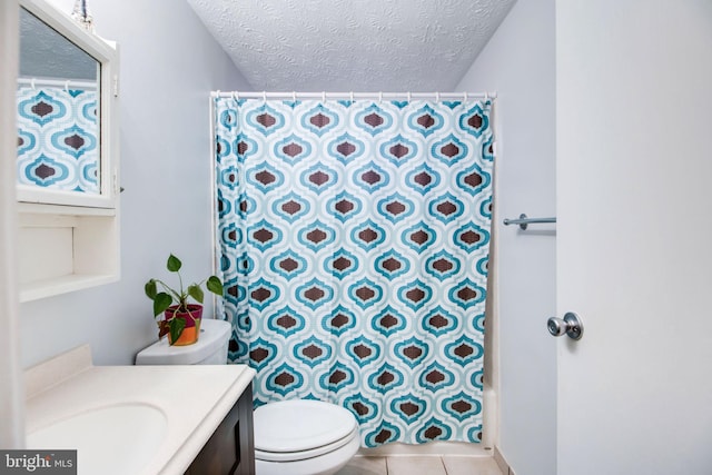 bathroom with tile patterned flooring, vanity, a textured ceiling, and toilet