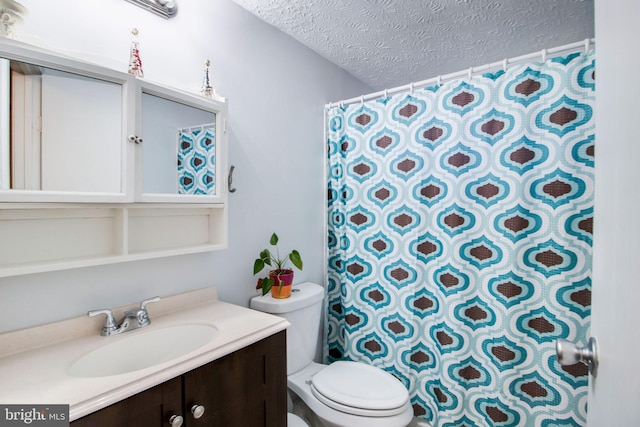 bathroom with vanity, a textured ceiling, and toilet