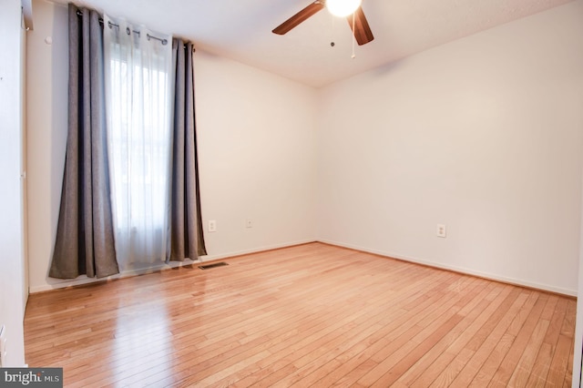 spare room with ceiling fan and light wood-type flooring