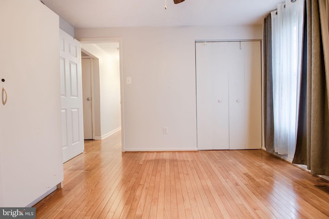 unfurnished bedroom featuring light hardwood / wood-style flooring and a closet