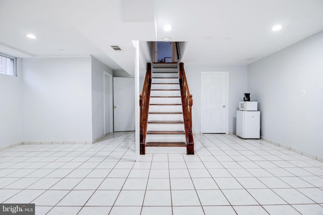 basement featuring light tile patterned flooring and washer / clothes dryer