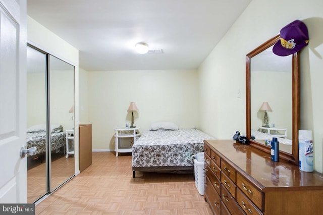 bedroom featuring a closet and light parquet flooring