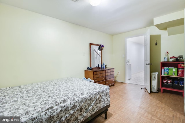 bedroom with washer / clothes dryer and light parquet floors