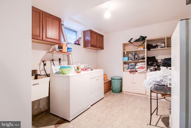 laundry room with washer and dryer, cabinets, and sink