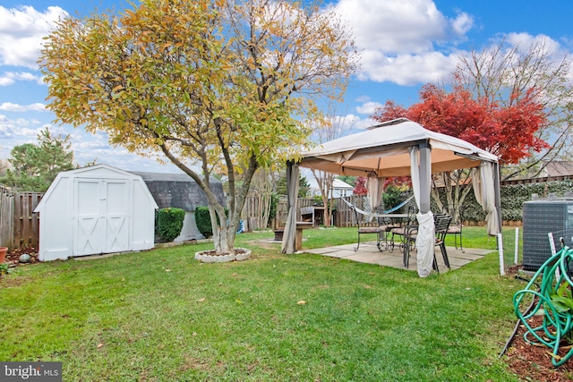 view of yard featuring a gazebo, a storage unit, cooling unit, and a patio area