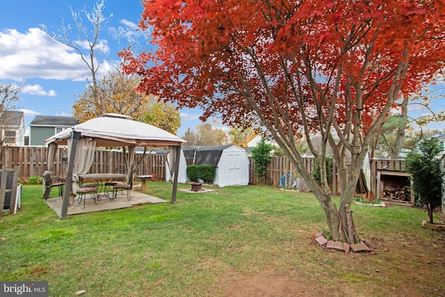 view of yard with a gazebo, a storage shed, and a patio