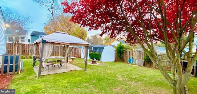 view of yard with a gazebo, a patio area, and a storage shed