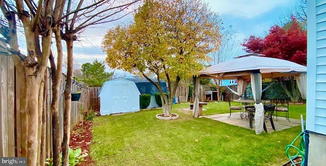 view of yard with a gazebo, a storage shed, and a patio area