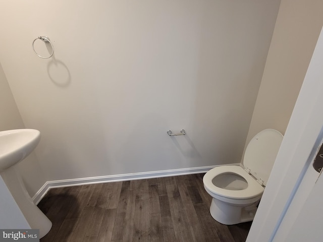 bathroom with toilet and hardwood / wood-style floors