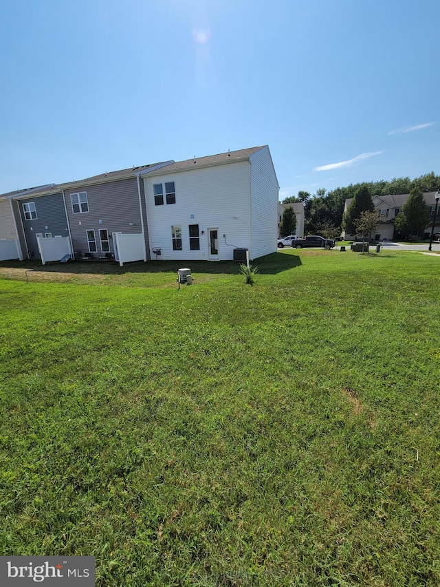 back of house with a yard and cooling unit