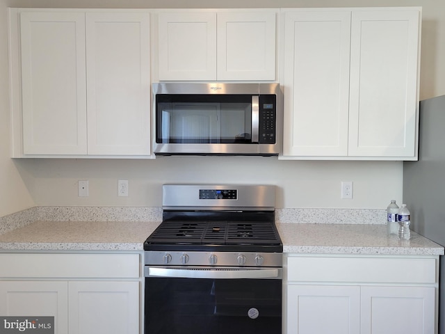 kitchen with white cabinetry and appliances with stainless steel finishes