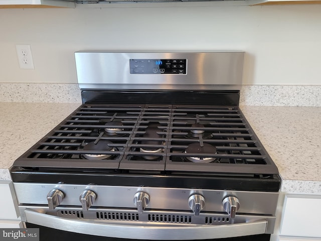 interior details featuring decorative backsplash and gas stove