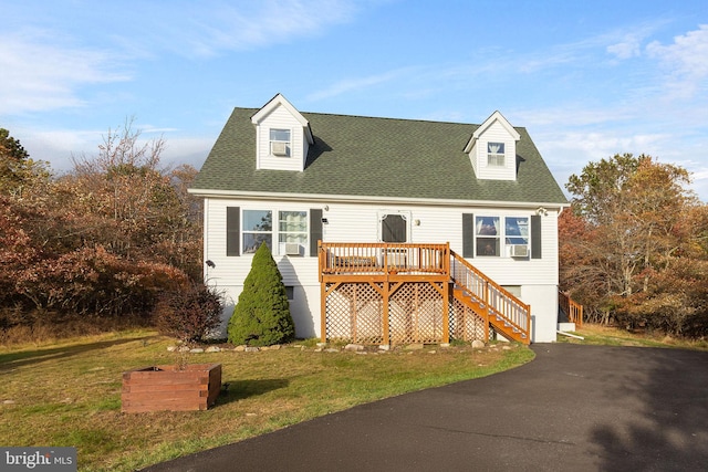 cape cod home with a front lawn and a wooden deck