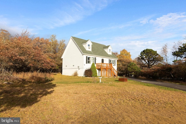 view of property exterior featuring a yard and a wooden deck