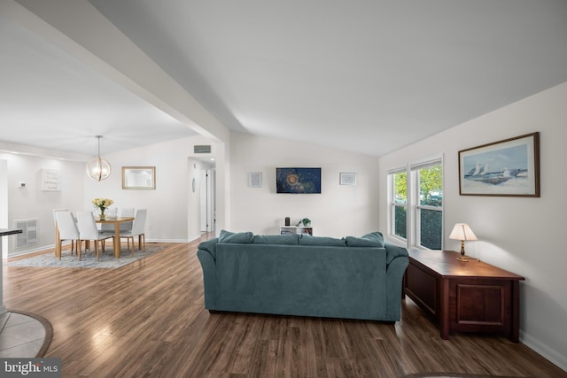 living room with dark wood-type flooring, lofted ceiling, and a notable chandelier