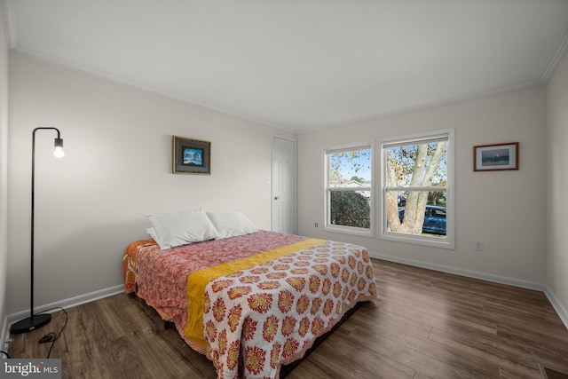 bedroom with crown molding and dark wood-type flooring