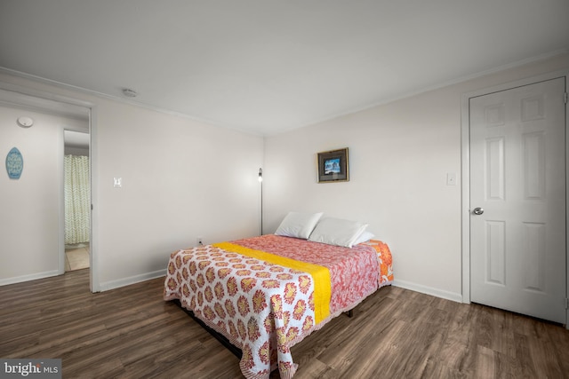 bedroom with ornamental molding and dark wood-type flooring