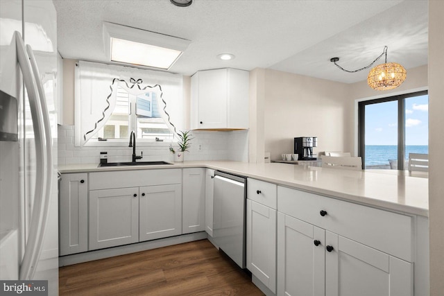 kitchen with a water view, a wealth of natural light, sink, and white refrigerator