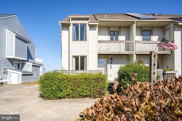 view of front of home with a balcony, a garage, and central air condition unit