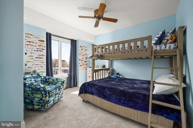 carpeted bedroom featuring ceiling fan and a textured ceiling