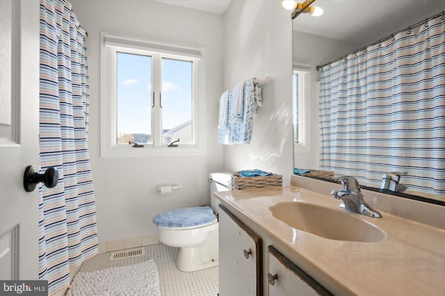 bathroom with vanity, toilet, and tile patterned floors