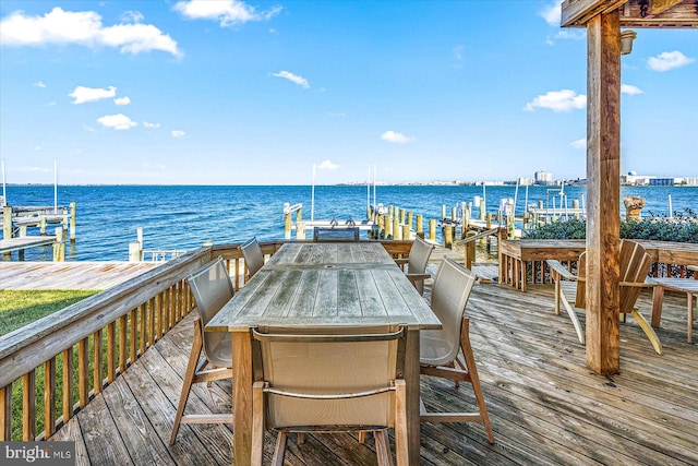 wooden deck with a dock and a water view