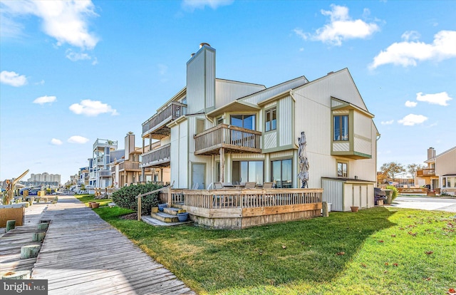 rear view of property featuring a balcony and a lawn